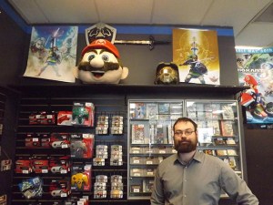 The branch manager of Game Changerz, Michael Morrissey, poses by some of his incredible videogame items.